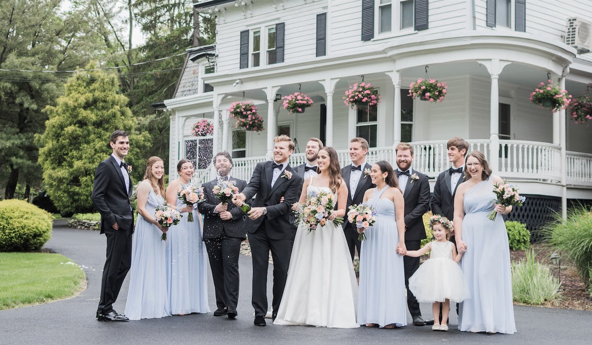 Wedding Party pops a bottle of champagne at Spring Hudson Valley NY wedding at Mountainville Manor